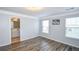 A bright bedroom features crown molding, two windows, and hardwood floors, with a view to the bathroom at 2201 Landing Walk Dr, Duluth, GA 30097