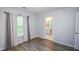 Bright bedroom features wood floors, a window with curtains, and an attached bathroom at 2201 Landing Walk Dr, Duluth, GA 30097