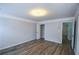 A bright bedroom features crown molding, a modern light fixture, and wood floors, with a view of the closet at 2201 Landing Walk Dr, Duluth, GA 30097