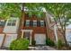 A charming red brick townhome featuring black shutters and a convenient single-car garage at 2201 Landing Walk Dr, Duluth, GA 30097