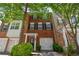 Charming brick townhome featuring black shutters, mature landscaping, and a convenient single-car garage at 2201 Landing Walk Dr, Duluth, GA 30097