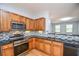 A kitchen features stainless steel appliances, a mosaic backsplash, dark countertops, and wood finish cabinetry at 2201 Landing Walk Dr, Duluth, GA 30097