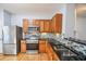 A kitchen features stainless steel appliances and a mosaic backsplash with dark countertops and wood finish cabinetry at 2201 Landing Walk Dr, Duluth, GA 30097