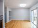 Open living room with hardwood floors, light gray walls, sliding glass doors, and a modern light fixture at 2201 Landing Walk Dr, Duluth, GA 30097