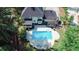 Aerial view showcases a large pool, lounge seating, and the home's rear facade at 4985 Miller Sw Rd, Lilburn, GA 30047