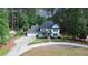 A bird's eye view of a beautiful home surrounded by mature trees, with a long driveway at 4985 Miller Sw Rd, Lilburn, GA 30047