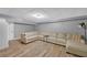 Finished basement featuring a comfortable sectional sofa, wood flooring, and neutral tones at 4985 Miller Sw Rd, Lilburn, GA 30047