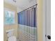Bright bathroom featuring a window, toilet, and shower with a stylish curtain at 4985 Miller Sw Rd, Lilburn, GA 30047