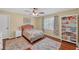 Comfortable bedroom features a bed with colorful bedding, a bookshelf, and natural light at 4985 Miller Sw Rd, Lilburn, GA 30047