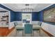 Elegant dining room featuring blue accent walls, a modern chandelier, and seating for four at 4985 Miller Sw Rd, Lilburn, GA 30047