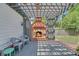Outdoor fireplace on a wooden deck with chairs and a pergola overhead at 4985 Miller Sw Rd, Lilburn, GA 30047