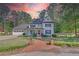 Traditional two-story home with white siding, red door and an attached three car garage at 4985 Miller Sw Rd, Lilburn, GA 30047