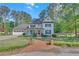 Charming two-story home with a manicured front lawn, red door, and a welcoming front porch at 4985 Miller Sw Rd, Lilburn, GA 30047