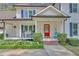 Inviting front porch with rocking chairs and a vibrant red door surrounded by lush greenery at 4985 Miller Sw Rd, Lilburn, GA 30047