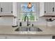 Close-up of a kitchen sink with granite countertop and ample natural light at 4985 Miller Sw Rd, Lilburn, GA 30047
