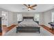 Spacious bedroom features a ceiling fan, large bed, wood floors, and lots of natural light at 4985 Miller Sw Rd, Lilburn, GA 30047
