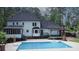 Rear exterior view highlights the pool, deck with pergola, fireplace, and screened porch at 4985 Miller Sw Rd, Lilburn, GA 30047