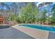 Outdoor swimming pool with chairs and a fireplace in a backyard setting at 4985 Miller Sw Rd, Lilburn, GA 30047