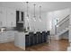 Kitchen featuring a waterfall island with bar seating, white cabinets, and a staircase with black railing at 88 Cleveland Unit B Se St, Atlanta, GA 30316