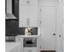 Kitchen with white cabinets, stainless steel appliances, a stylish black backsplash, and modern hardware at 88 Cleveland Unit B Se St, Atlanta, GA 30316