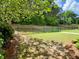 Serene backyard featuring a black metal fence, landscaped area, and lush greenery, offering a peaceful retreat at 1093 Spruce Creek Ln, Lawrenceville, GA 30045