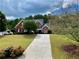 Beautiful brick home with a well-kept lawn and long driveway lined by trees at 1093 Spruce Creek Ln, Lawrenceville, GA 30045