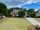 Attractive brick home with a large front lawn and long driveway surrounded by mature trees at 1093 Spruce Creek Ln, Lawrenceville, GA 30045