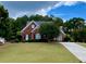Traditional brick home with a manicured lawn, black shutters, and mature trees at 1093 Spruce Creek Ln, Lawrenceville, GA 30045