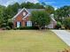 Charming red brick home with a well-manicured lawn and mature trees at 1093 Spruce Creek Ln, Lawrenceville, GA 30045