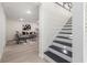 Finished basement with light wood floors and staircase with black treads and white risers at 176 Rhodesia Se Ave, Atlanta, GA 30315