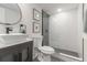 Modern bathroom features a sleek vanity, round mirror, and glass-enclosed shower with stylish gray and white tiling at 176 Rhodesia Se Ave, Atlanta, GA 30315