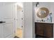 Stylish powder room with a wood vanity, unique round mirror and modern lighting at 176 Rhodesia Se Ave, Atlanta, GA 30315