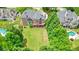 Aerial view of a home with a sprawling lawn, bordered by mature trees, and neighboring houses with pools at 3689 Spring Hill Se Rd, Smyrna, GA 30080
