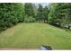 Manicured backyard lawn surrounded by mature trees, as viewed from the deck at 3689 Spring Hill Se Rd, Smyrna, GA 30080