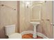 Elegant powder room with pedestal sink, decorative mirror, and stylish patterned wallpaper at 3689 Spring Hill Se Rd, Smyrna, GA 30080