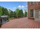 Spacious wooden deck with a dark brown stain and grill, overlooking a wooded backyard at 3689 Spring Hill Se Rd, Smyrna, GA 30080