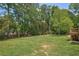 View of wide, well-manicured green backyard with wooded boundary and elevated wooden deck at 3783 Ardsley Ct, Marietta, GA 30062
