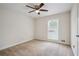 Bright bedroom features neutral carpeting, a ceiling fan, and a window allowing natural light to fill the room at 3783 Ardsley Ct, Marietta, GA 30062