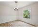Bright dining room featuring wainscoting and a modern chandelier, complemented by a view of the lush outdoors at 3783 Ardsley Ct, Marietta, GA 30062