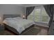 Bright bedroom with hardwood floors, large window, and neutral paint at 6614 Covered Bridge Way, Braselton, GA 30548