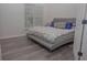 Contemporary bedroom with grey vinyl flooring, large window, and modern platform bed at 6614 Covered Bridge Way, Braselton, GA 30548