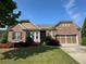 Charming brick home with an attached garage and colorful landscaping at 6614 Covered Bridge Way, Braselton, GA 30548