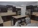Modern kitchen featuring dark cabinets, granite countertops, and stainless steel appliances at 6614 Covered Bridge Way, Braselton, GA 30548