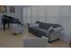 Comfortable living room with tufted sofa, chairs, and black piano at 6614 Covered Bridge Way, Braselton, GA 30548