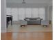 Elegant living room with a grand piano, grey sofa and bright windows with natural light at 6614 Covered Bridge Way, Braselton, GA 30548