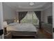 Main bedroom with tray ceiling, dresser, and large windows offering natural light at 6614 Covered Bridge Way, Braselton, GA 30548