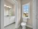 Bathroom showcasing a toilet, shower, and white vanity with stone countertops and a window at 7235 Cordery Rd, Cumming, GA 30040