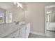 Bathroom featuring a large mirror over a double vanity with stone countertops at 7235 Cordery Rd, Cumming, GA 30040