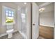 Bathroom featuring a glass enclosed shower, toilet, and window providing natural light at 7235 Cordery Rd, Cumming, GA 30040