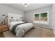 Bedroom featuring a tufted headboard, bedside lamps, and a large window with a view at 7235 Cordery Rd, Cumming, GA 30040